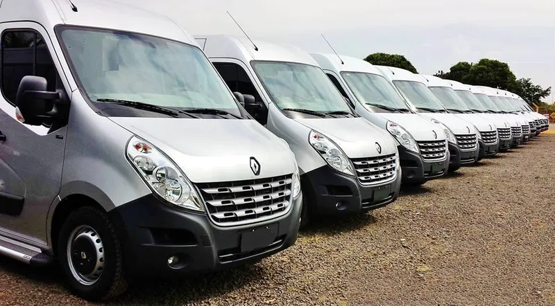 Frota de vans executivas prateadas perfiladas, prontas para operação de fretamento em Salvador