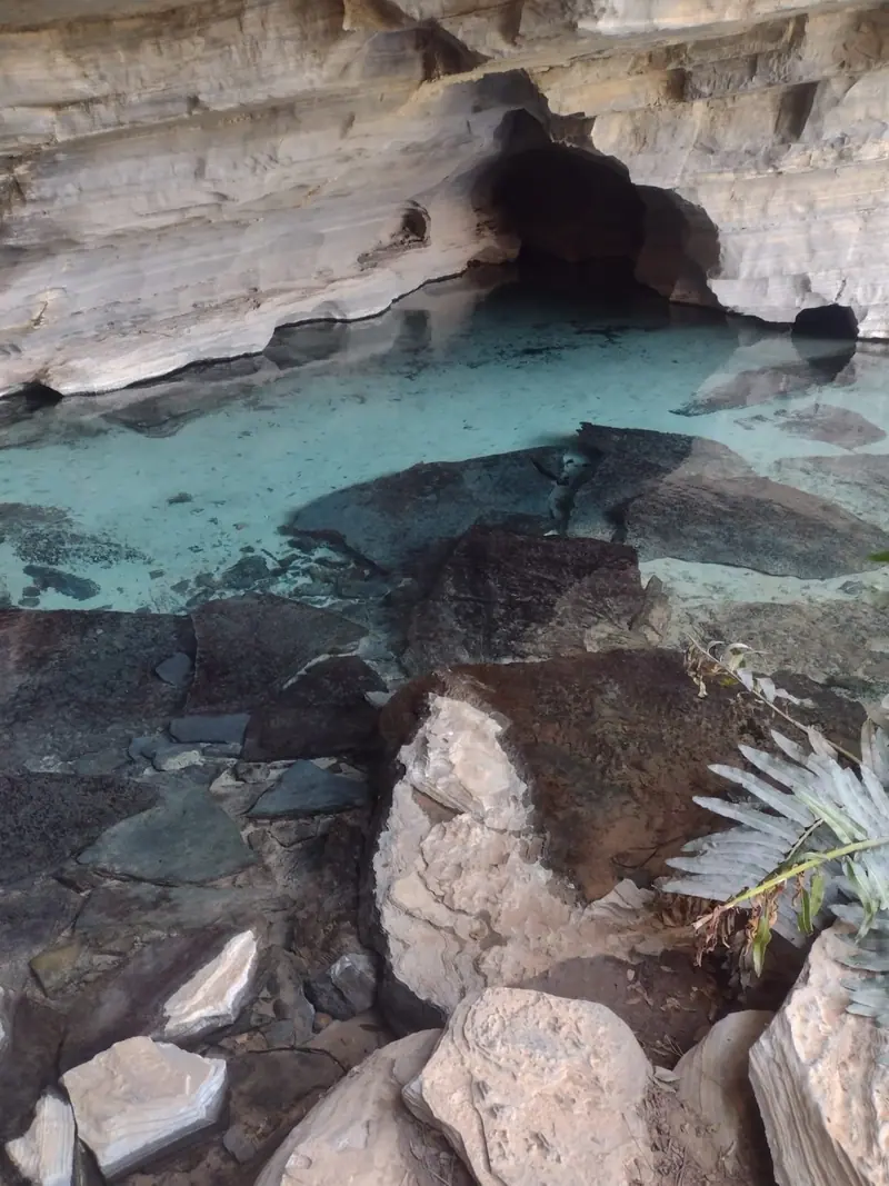 Água turquesa transparente sob a rocha em caverna da região da Pratinha, Chapada Diamantina