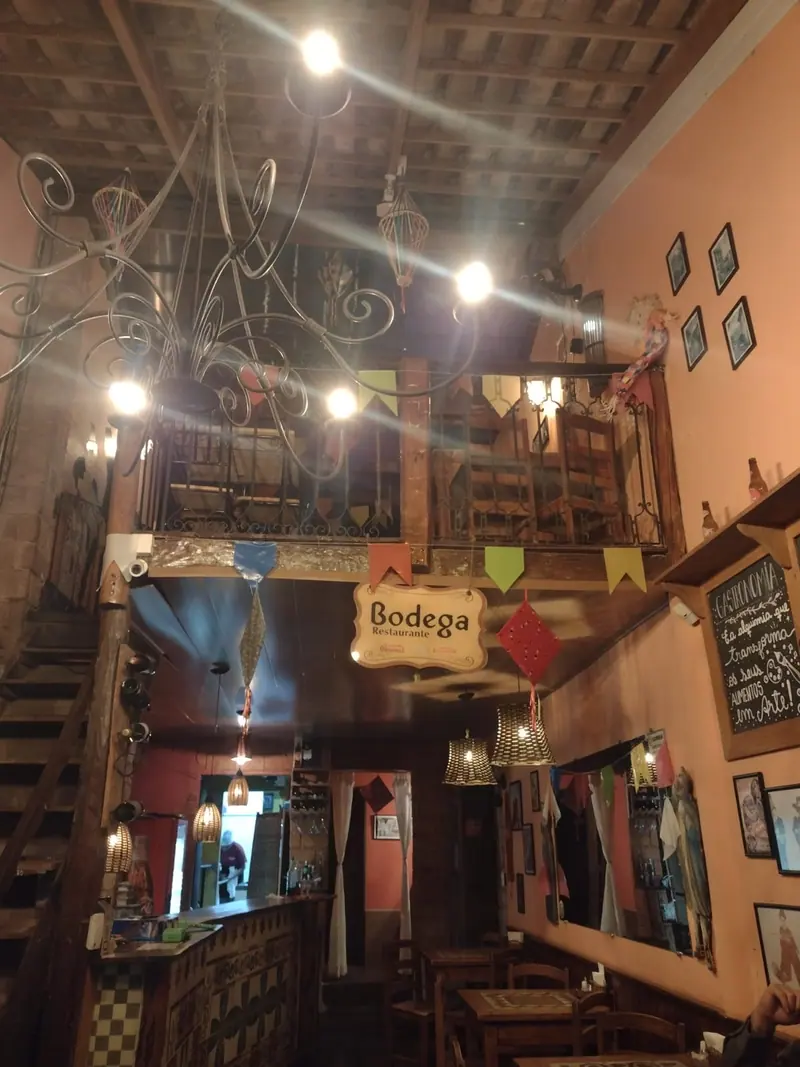 Salão interno de restaurante em Lençóis, com lustre de ferro, bandeirinhas e mobiliário rústico
